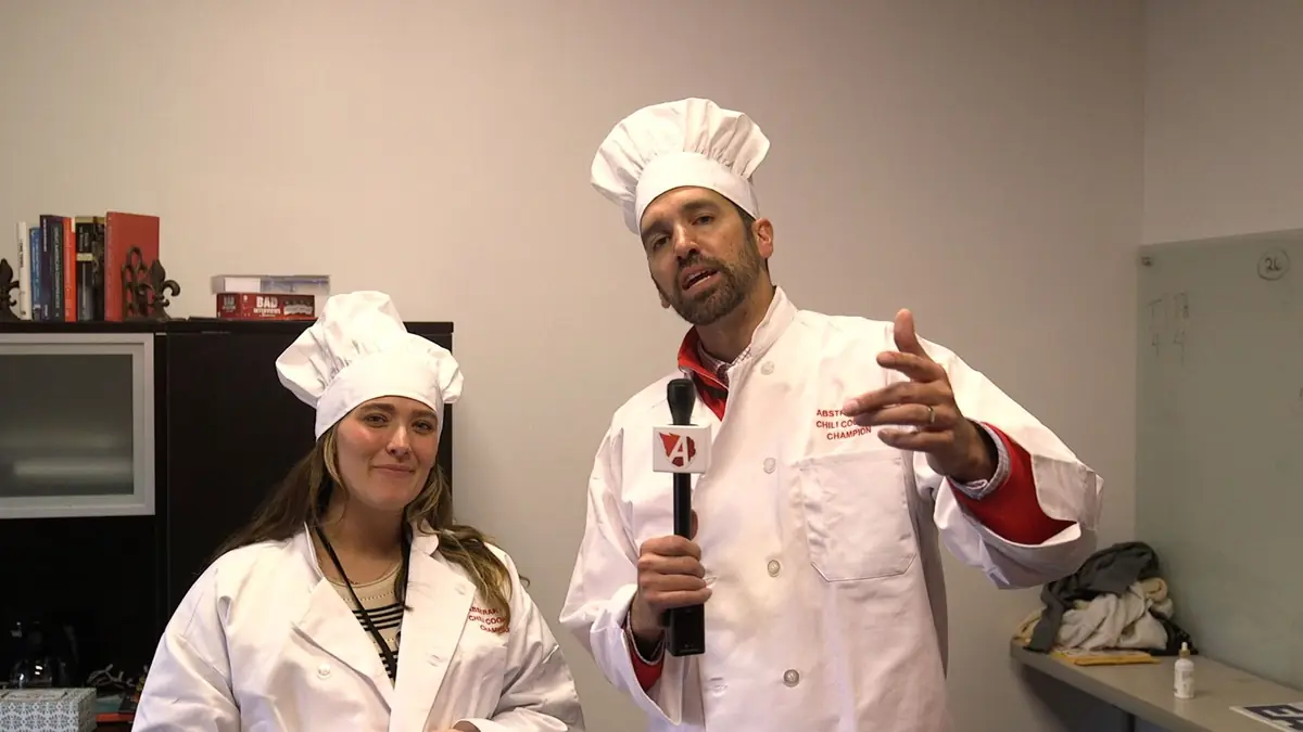 Team members in chef hats at the office chili cook-off