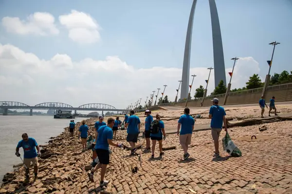 Abstrakt volunteers cleaning up the St. Louis riverfront below the Gateway Arch on Give Back Day