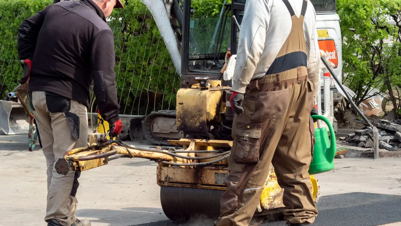 Paving crew compacting fresh asphalt