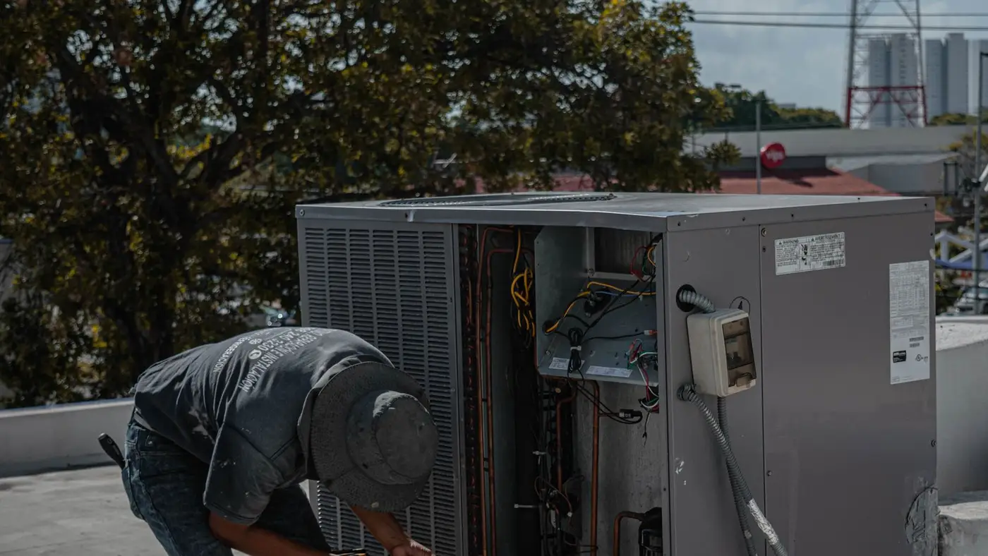 Technician working on a rooftop air conditioning unit